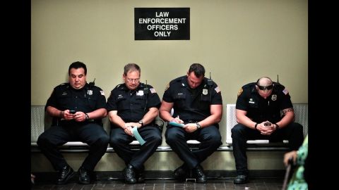 Memphis police officers wait outside of Division 3 Traffic Court in case they are needed to testify. Hundreds of the city's officers have called in sick to protest healthcare benefit cuts. 
