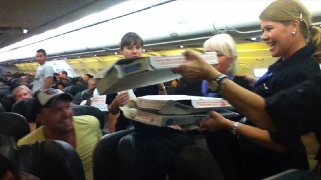 handing out pizza to passengers stranded on a plane