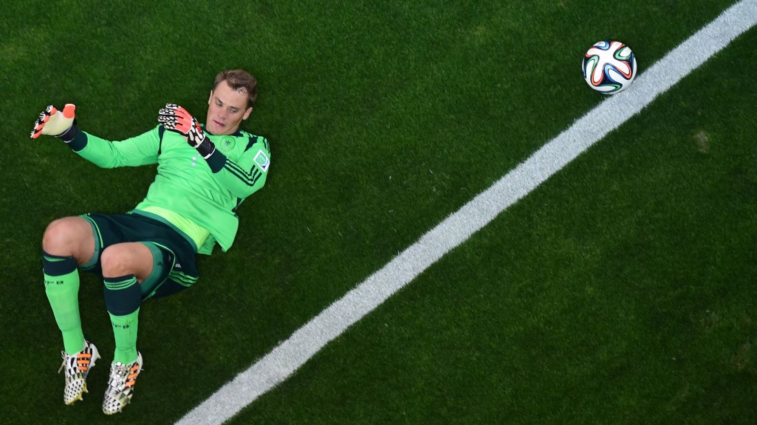 Neuer lies on the grass in the penalty box.