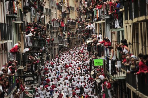 Revelers run on a street in Pamplona on July 9.