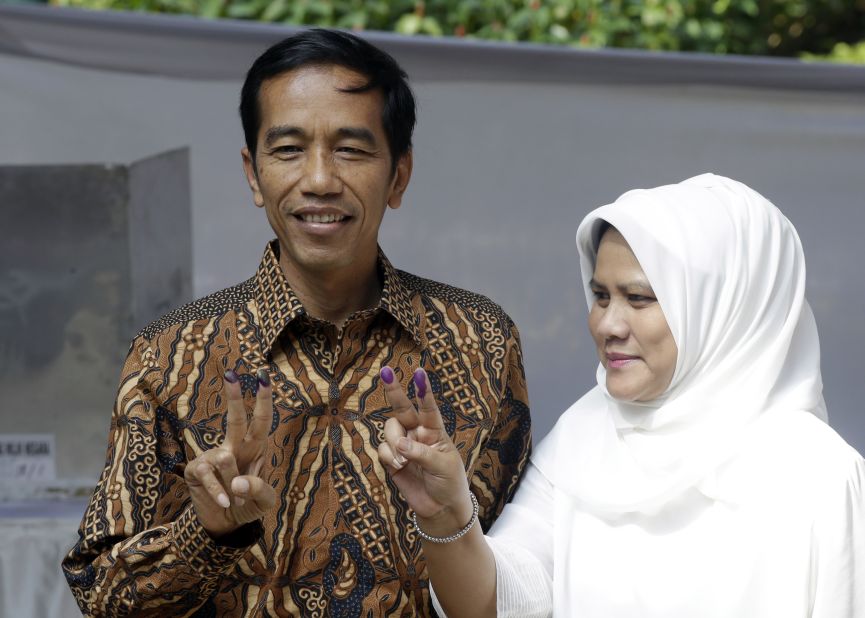 Indonesian presidential candidate Joko Widodo, at left, and his wife Iriana, show their inked fingers after casting their ballots during the presidential election in Jakarta on July 9.