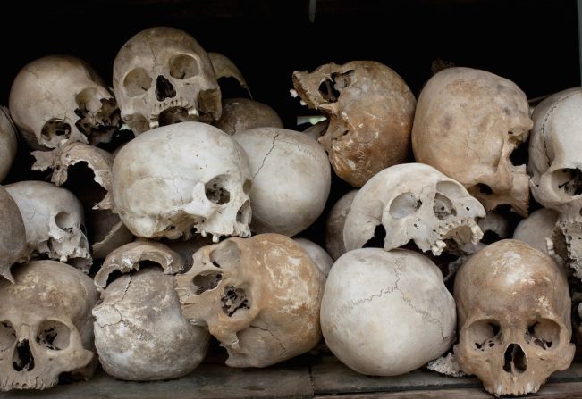 Some of the 8,000 human skulls at the Choeung Ek Genocidal Center in Cambodia sit in a glass case. 