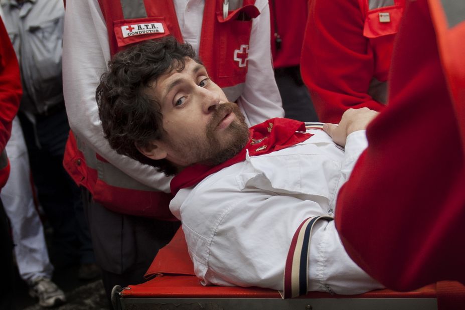 Bill Hillmann, a 32-year-old man from Chicago, is carried on a stretcher after he was gored on his right leg during the annual <a href="http://www.cnn.com/2014/07/07/world/gallery/running-of-the-bulls/index.html">running of the bulls</a> Wednesday, July 9, in Pamplona, Spain. Hillmann has been running in Pamplona for about a decade, and he recently co-authored a book entitled "Fiesta, How to Survive the Bulls of Pamplona."