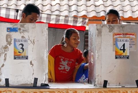 Children wait for their parents who vote in the presidential election in Bali on July 9. As the world's third-largest democracy held an election for a new president.