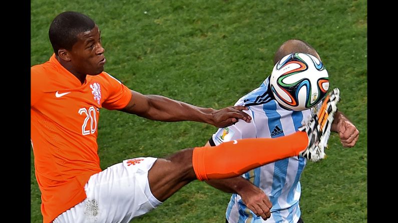 Georginio Wijnaldum of the Netherlands kicks the ball near Mascherano.