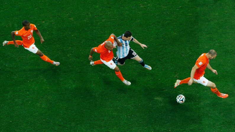 Three Dutch players defend Messi.