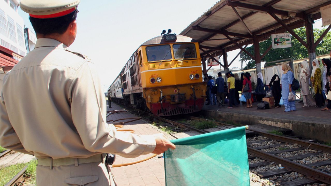 FILE PHOTO: A railway guard gives the green signal to a train in Thailand's southern Yala province.