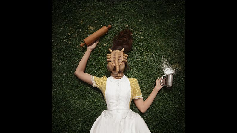 A starring feature of McConnell's photos are her extraordinary cakes -- elaborate creations she bakes from scratch in her kitchen, marrying their delicious sweetness with varying degrees of menace. The terrifying mask shown above is in fact a cookie, made from nutmeg, milk, and sugar, and glazed with caramel. "I've always loved that Stepford Wives look, and I am very enamored with that tradition of early America," says McConnell, "but I also really love sci-fi, things which are spooky and a little bit creepy," she adds.