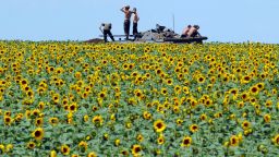 Ukrainian soldiers sit on an armored vehicle as they take up a position in a sunflower field near Donetsk, Ukraine, on Thursday, July 10.
