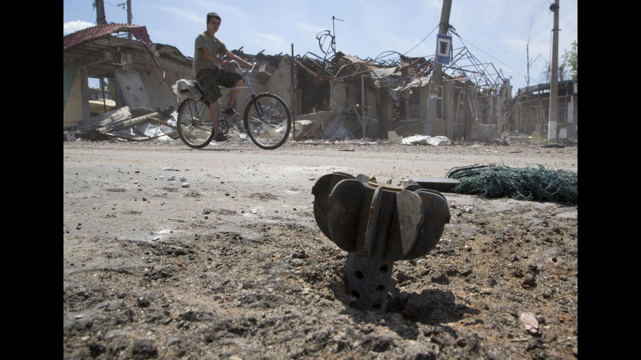 A man rides a bike past the tail of a bombshell outside Slovyansk, Ukraine, on July 10.