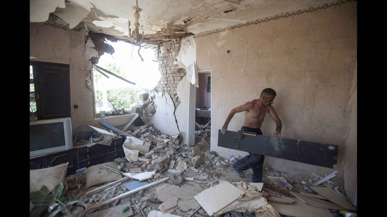 A man cleans up debris in his apartment after a shelling in Slovyansk on July 10.