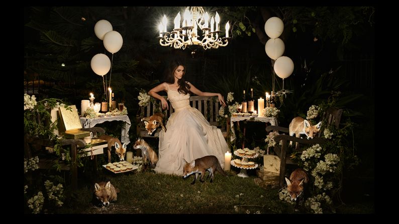 The setting is eerily calm.<br /><br />A beautiful girl sits on a bench surrounded by remnants of a party, while wild foxes roam and feast on her baked creations. Her gaze is lowered, and there is a mysterious atmosphere, with dark shadows concealing unknown dangers. <br /><br />If you are unsettled by this scene, this is exactly what the photographer <a target="_blank" target="_blank">Christine McConnell</a>, pictured above, was trying to achieve. In her images, the Los Angeles-based artist combines the glamor of 1950s pin-ups with Tim Burtone-esque elements of twisted fantasy. <br /><br />By <a target="_blank" target="_blank"><strong>Milena Veselinovic</strong></a>, for CNN