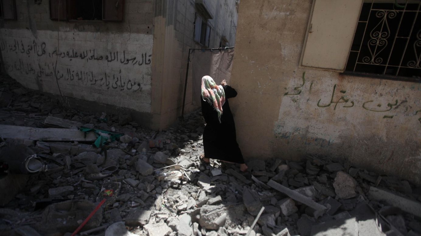 A Palestinian woman carries belongings from her family's house, which police said was destroyed in an Israeli airstrike in Gaza City on Wednesday, July 9. In response to continuing rocket attacks from Hamas and other militants in Gaza, Israel has begun <a href="http://www.cnn.com/2014/07/10/world/meast/mideast-tensions/index.html">its own wave of aerial bombardment.</a> Israeli Prime Minister Benjamin Netanyahu said the offensive would continue "until the firing at our communities stops and quiet is restored."