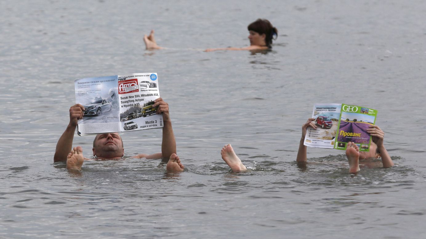A couple reads magazines as they float in the salt waters of Lake Tus in Russia's Khakassia region, southwest of the Siberian city of Krasnoyarsk, on Saturday, July 5. During the summer, many Russians travel to the lake, famous for the curative properties of its black and blue sediments, to bathe in the salty water and smear themselves with mud.