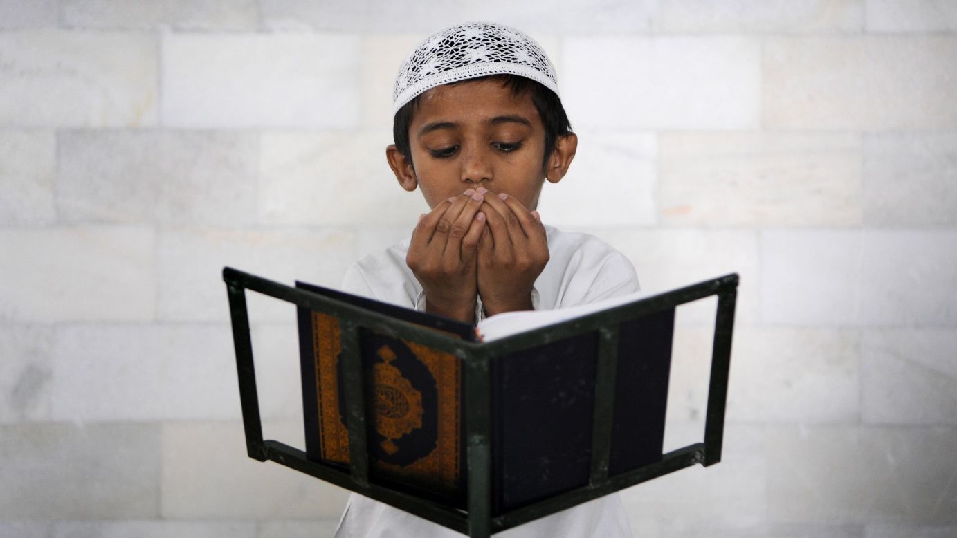 A Muslim boy recites verses from the Quran at a mosque in Noida, India, on Wednesday, July 9. During <a href="http://religion.blogs.cnn.com/2014/06/28/the-belief-blog-guide-to-ramadan/">the holy month of Ramadan</a>, Muslims across the globe are abstaining from food, drink and other pleasures during daylight hours. Many call it a time of spiritual purity and rededication to God.