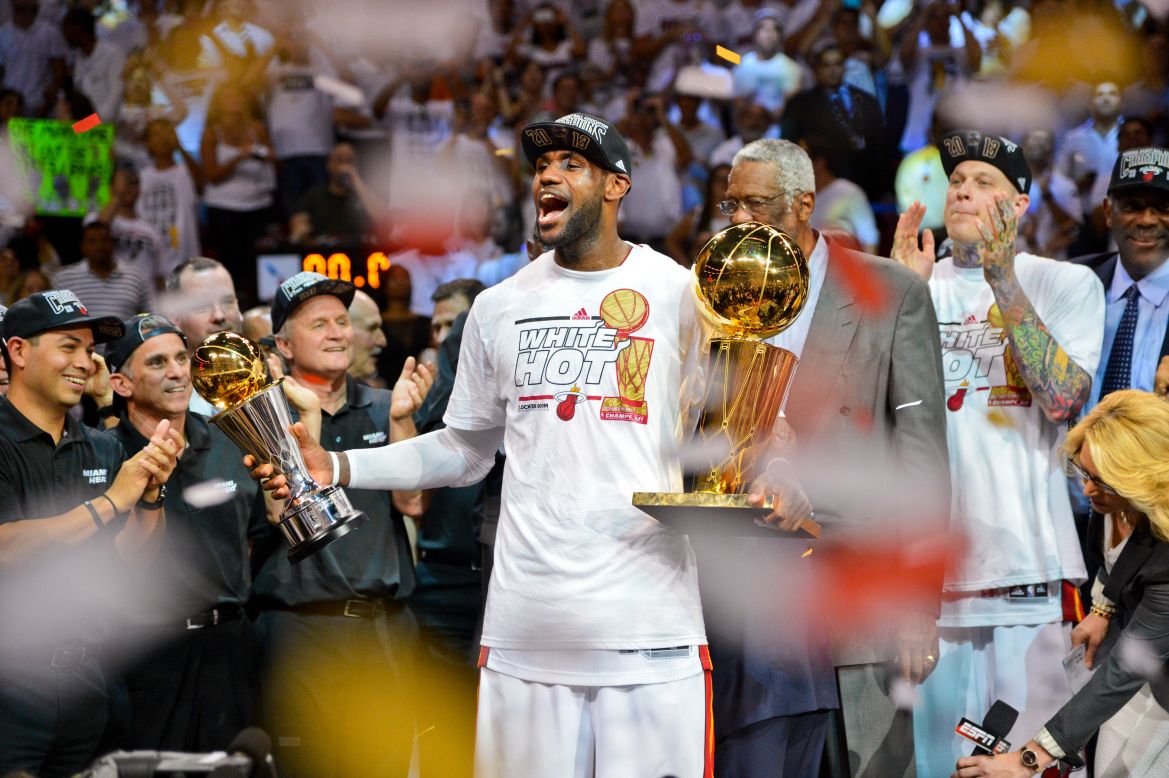 James holds the Finals MVP trophy and the Larry O'Brien Championship trophy after the Heat defeated the San Antonio Spurs to win back-to-back titles in June 2013.