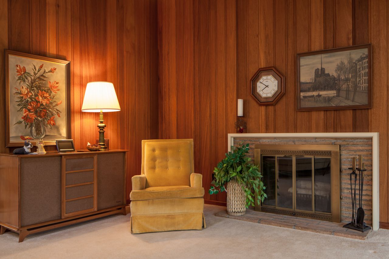 Everything about this room, from the chair, to the paneling, to the paintings, adds to the 1950s feel.