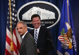 Attorney General Eric Holder (L) and FBI Director James Comey (R) leave after a major law enforcement action announcement at the Justice Department June 30, 2014 in Washington.