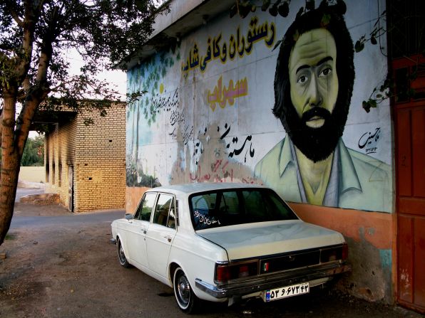 Two common sights of Iran: murals of the war "martyrs" and the ubiquitous Paykan, a vehicle also known as the Iranian chariot.