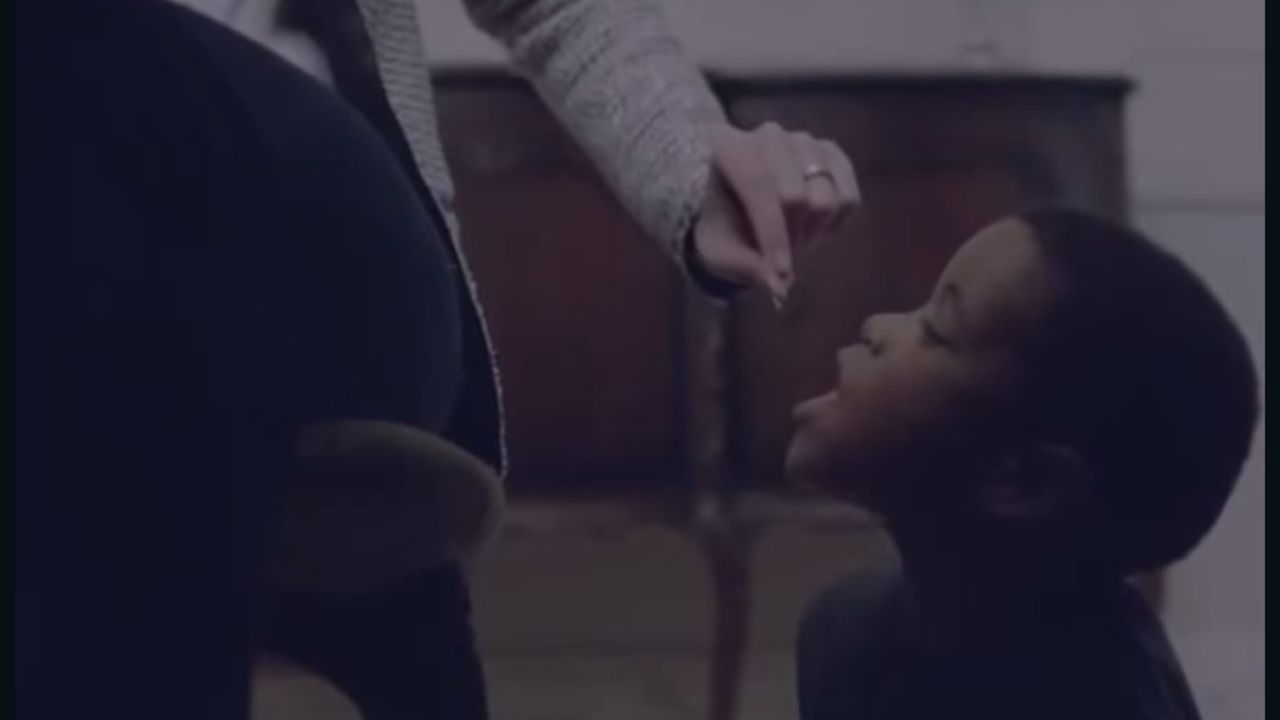 The withdrawn advertisement shows a white woman feeding a young black boy like a pet.