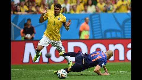 Brazil defender and captain Thiago Silva, left, reacts after fouling Netherlands forward Arjen Robben.