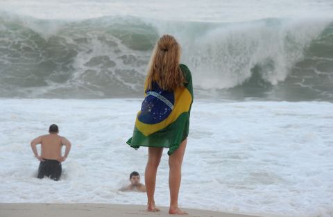 A fan of Brazil stands on the shore of Copacabana beach in Rio de Janeiro.