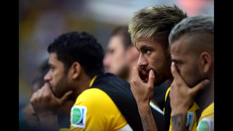 Brazil's injured player Neymar, right, is seen on the bench during the game. 
