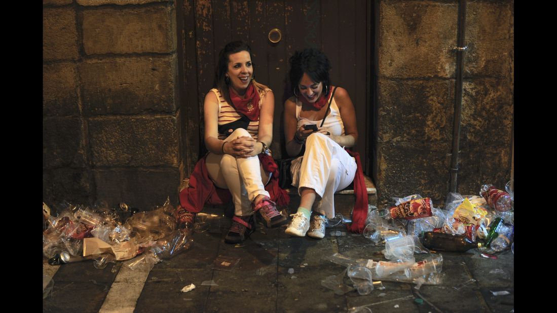 Two women sit on the street during the San Fermin festival on July 12. 