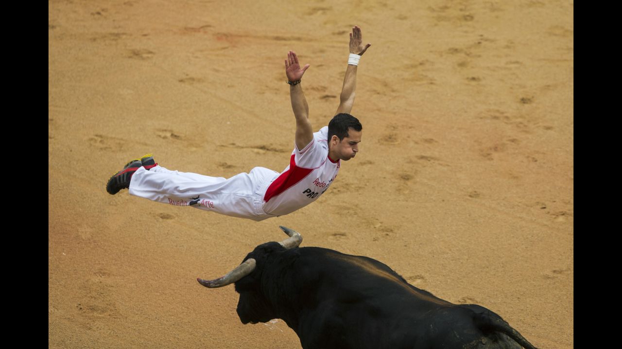 A ''recortador'' jumps over a bull during a competition at the festival on July 12. Recortadors leap over the bulls in a bloodless version of bullfighting where the one getting the closest and showing the least fear wins.
