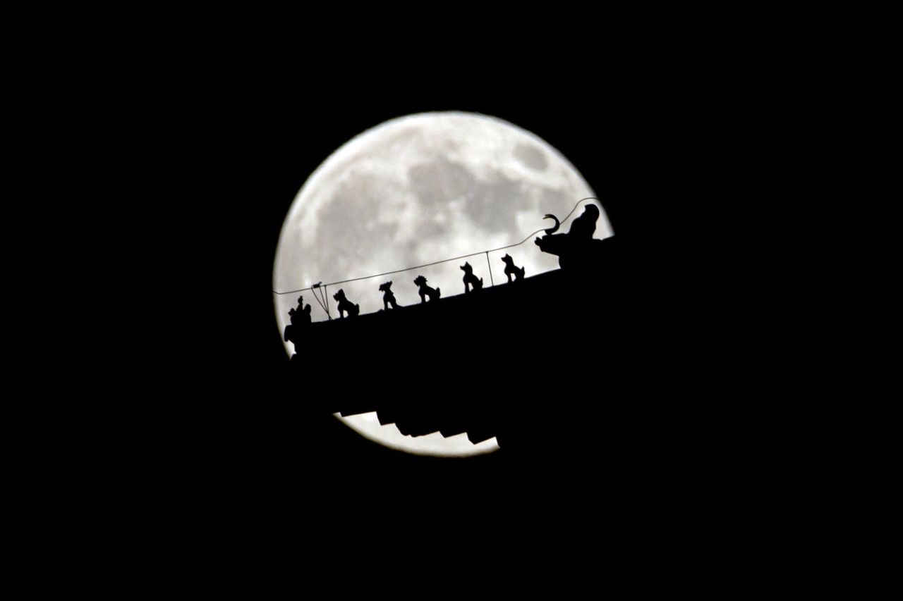 The moon rises behind figurines on a pavilillon in Beijing, China. Due to it's closer proximity to the Earth the moon appears larger and brighter than normal. 