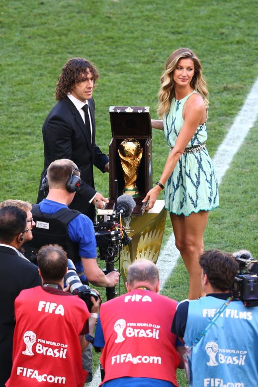 El exjugador de la selección española, Carles Puyol, junto a la modelo Gisele Bundchen, presentando la Copa del Mundo en una pequeña maleta de Louis Vuitton en el estadio de Maracaná, en Río de Janeiro.