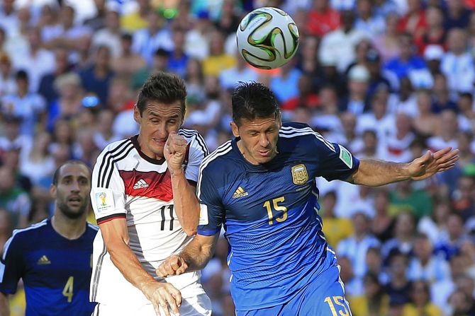 Klose, left, goes up for a header with Argentine defender Martin Demichelis.