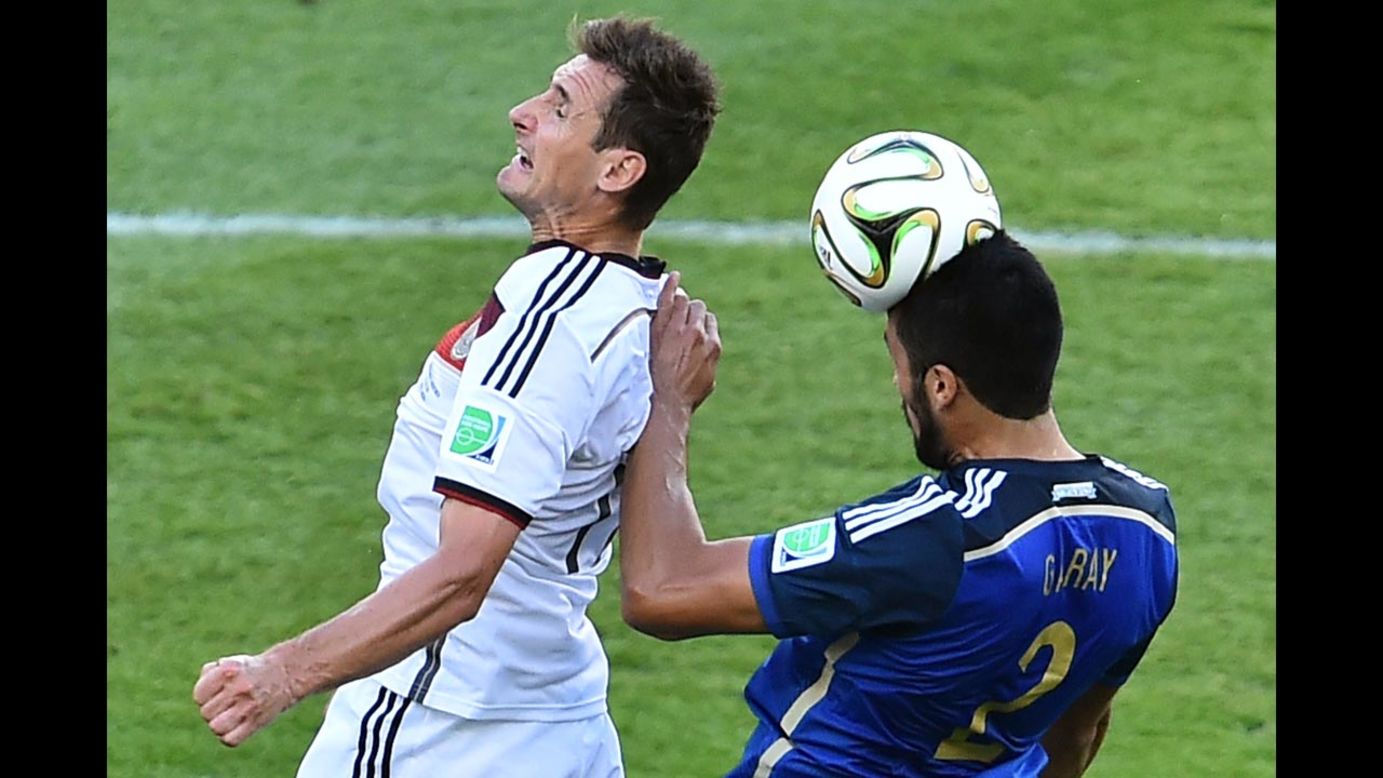 German forward Miroslav Klose, left, and Argentine defender Ezequiel Garay compete for the ball.