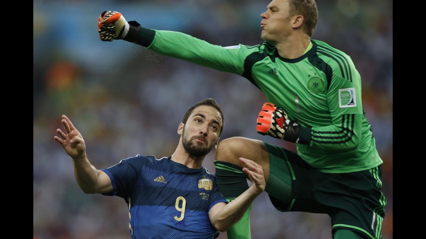 Neuer punches the ball before colliding with Higuain.