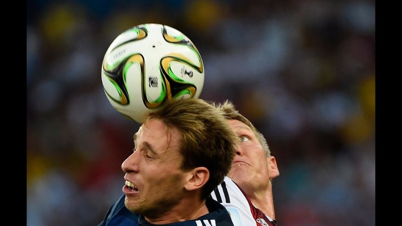 Biglia, left, and Schweinsteiger head the ball.