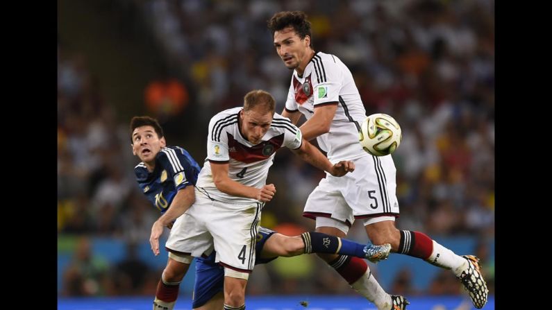 German defender Benedikt Howedes heads the ball away near Messi, left, and teammate Mats Hummels.