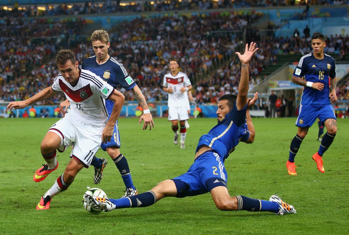 Ezequiel Garay intentando bloquear el balón de Miroslav Klose durante la final del Mundial.