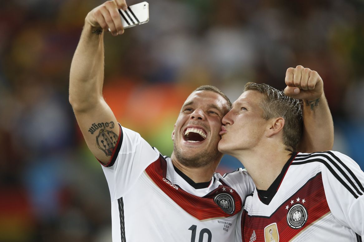 Germany's Lukas Podolski, left, takes a selfie with teammate Bastian Schweinsteiger after the match.
