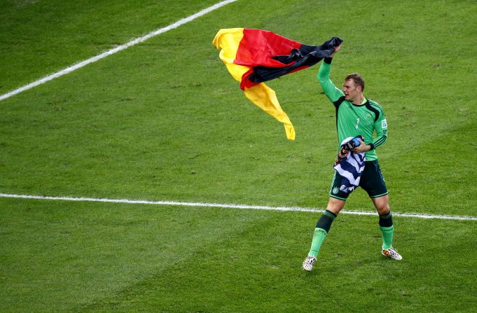 Goalkeeper Manuel Neuer celebrates with a German flag after the match.