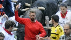 A participant runs in front of Jandilla's bulls as he takes a 'selfie' (photograph of himself) during the fifth bull-run of the San Fermin Festival in Pamplona, northern Spain, on July 11, 2014. Spanish authorities are cracking down on dare devils who shoot camera footage even as they risk their lives by running with half-tonne fighting bulls at the annual San Fermin festival. PHOTO/ RAFA RIVAS (Photo credit should read RAFA RIVAS/AFP/Getty Images)