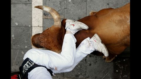 A bull horns a runner in Pamplona, Spain, on the last day of the San Fermin festival's annual running of the bulls Monday, July 14. The bull run, a 400-year tradition, takes place over eight days.
