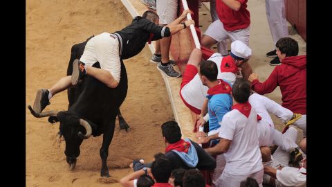 A man tries to protect himself July 14 in the bull ring where each bull run ends.
