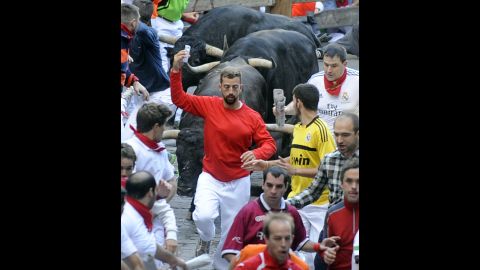 A man takes a selfie as he runs in front of bulls on Friday, July 11.