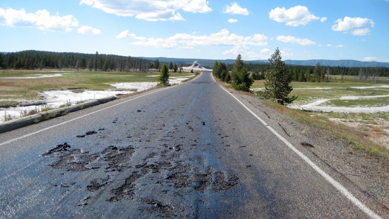 A road in Yellowstone National Park simmers in the heat of underground thermal features.