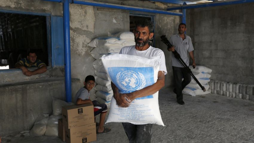 A Palestinian man carries a bag that he received at an aid distribution centre of the United Nations Relief and Works Agency (UNRWA) on July 14, 2014 in Gaza City.