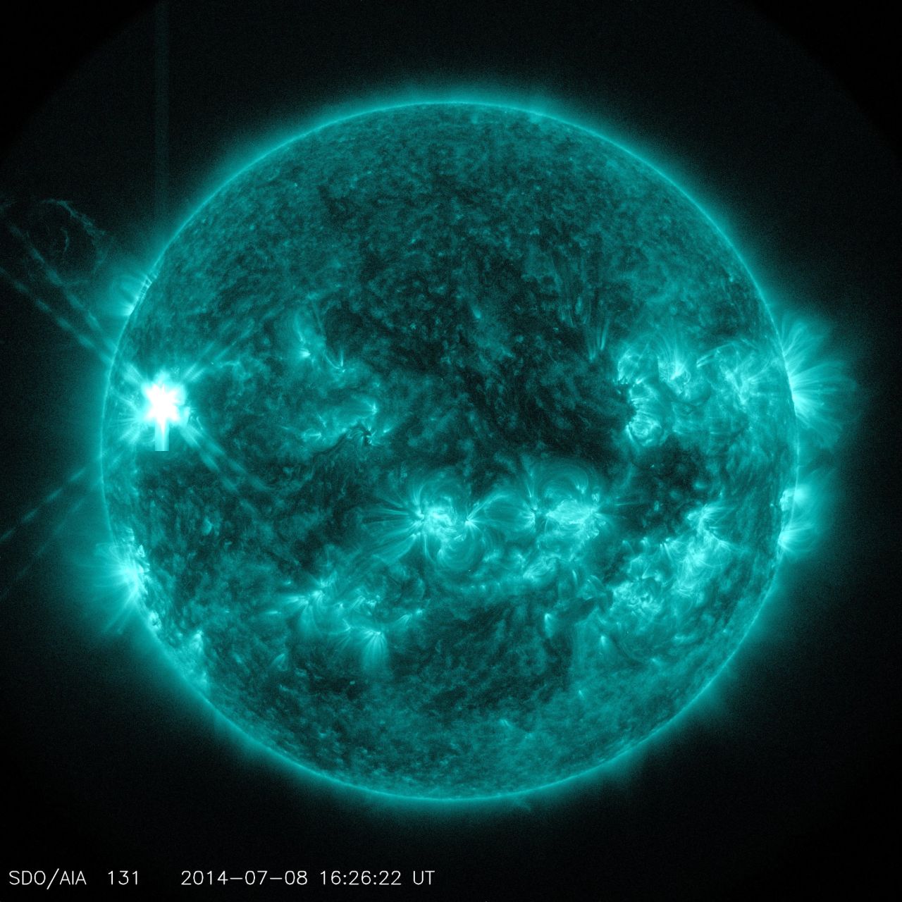 A midlevel flare erupted on the left side of the sun on July 8, 2014. This image from NASA's Solar Dynamics Observatory highlights the high-temperature solar material in a flare, which is typically colorized in teal. 