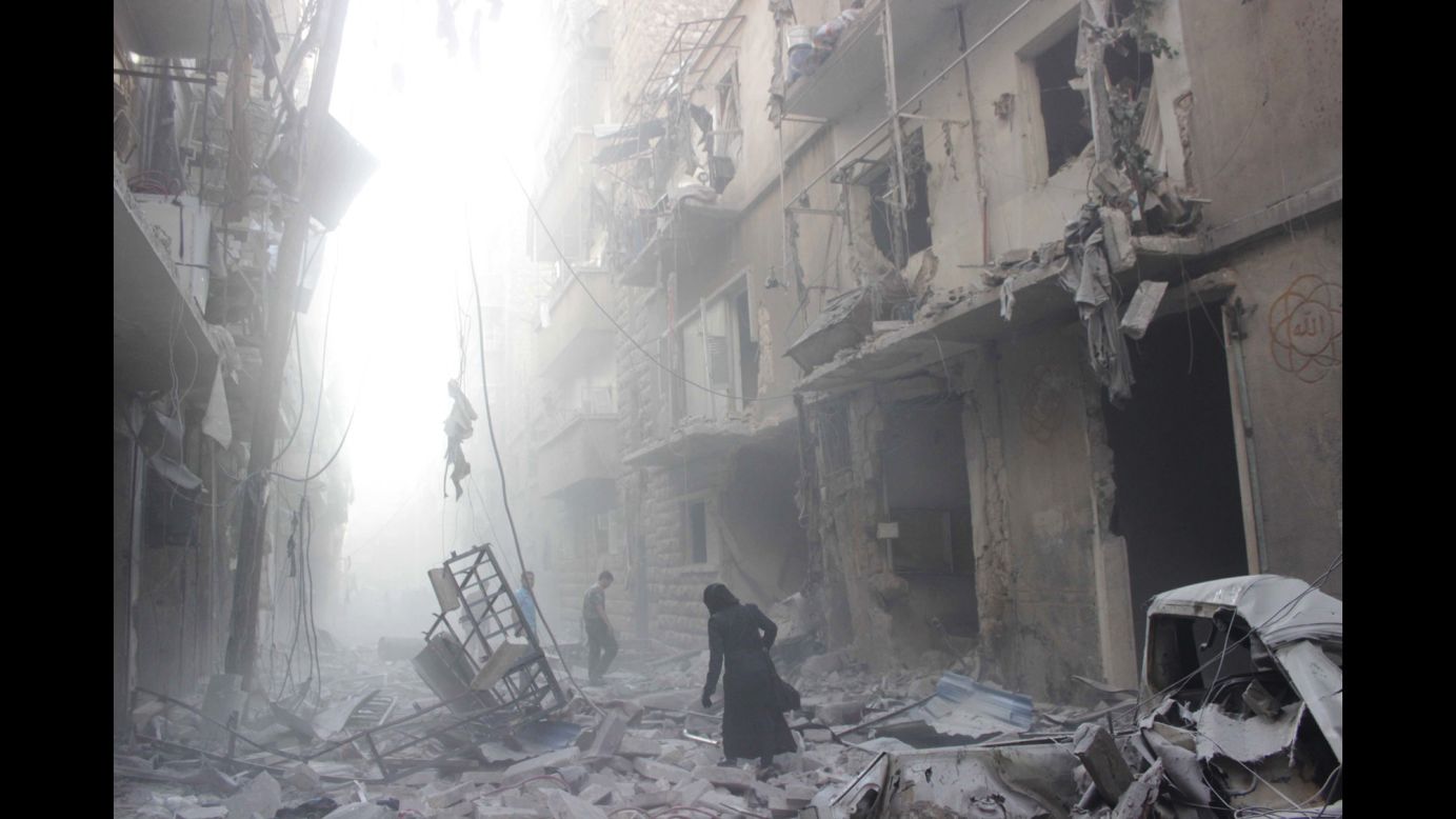 A woman walks amid debris after an airstrike by government forces July 15 in Aleppo.