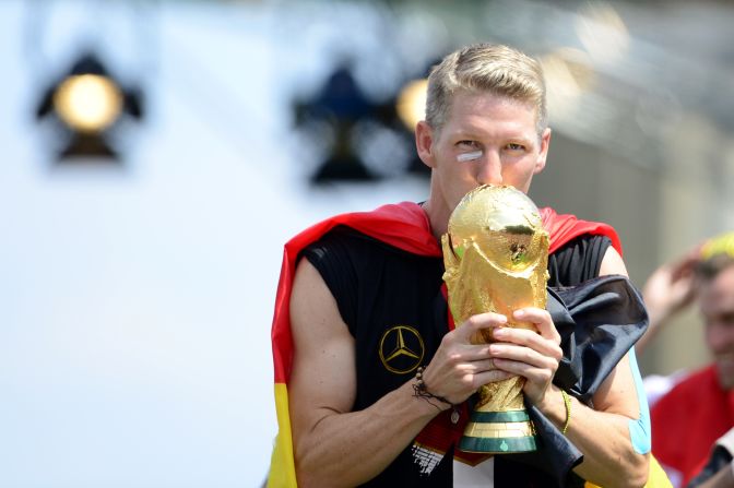 Germany's midfielder Bastian Schweinsteiger kisses the trophy.