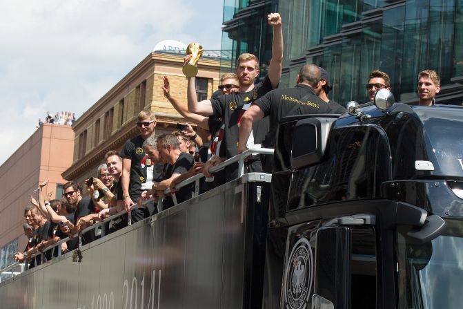 Next stop for the German team is a parade through Berlin. Defender Per Mertesacker shows off the trophy to the adoring crowd.