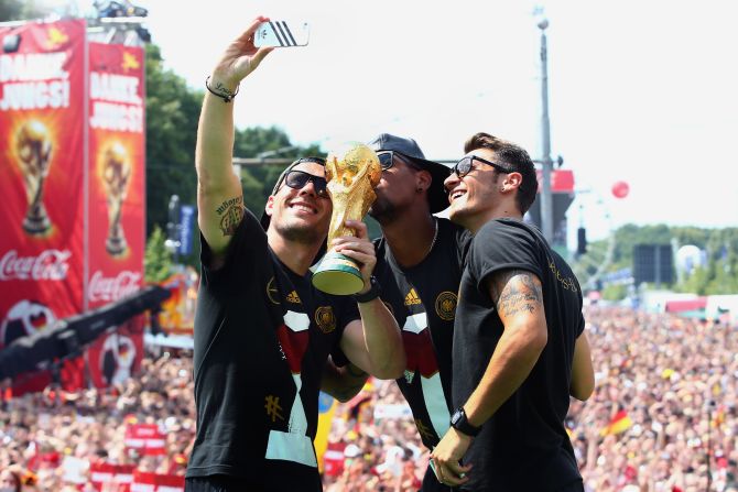 A celebration just isn't the same without a selfie with the World Cup trophy as Lukas Podolski, Jerome Boateng and Mesut Oezil discover.